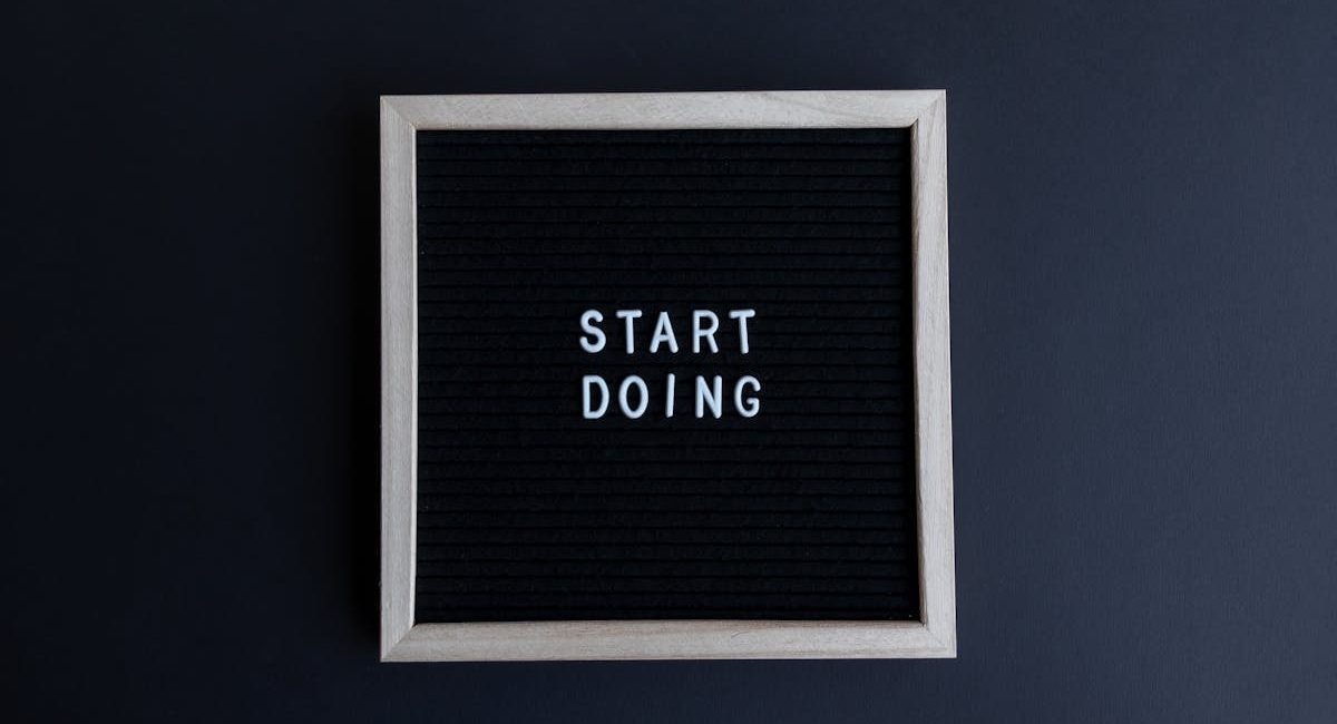 Black letter board with the motivational phrase 'Start Doing' in white text on a gray background.